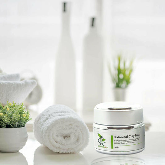 botanical clay mask with a towel next to is and a green plant on the left and two large white bottles in the background