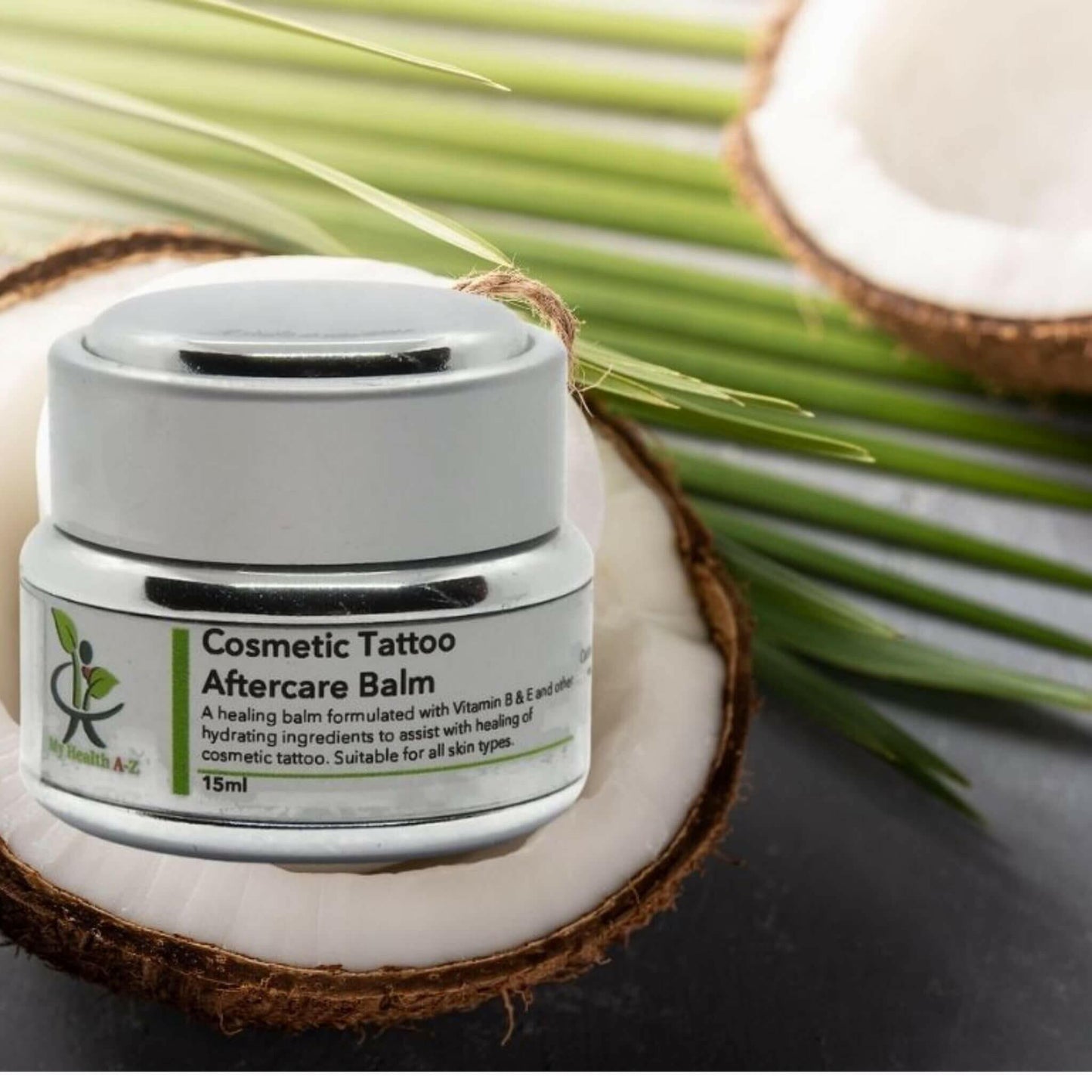 Cosmetic Tattoo Aftercare Balm jar on a coconut with coconut leaf in the middle