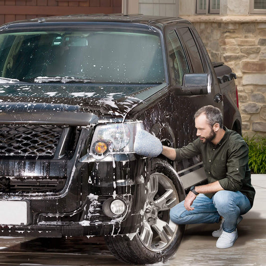 man washes his car with a microfibre car wash mitt